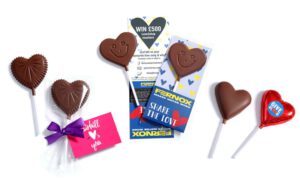 An assortment of heart-shaped lollipops and a gift card with a purple bow. The card and packaging promote a contest and feature the message "Share the Love.
