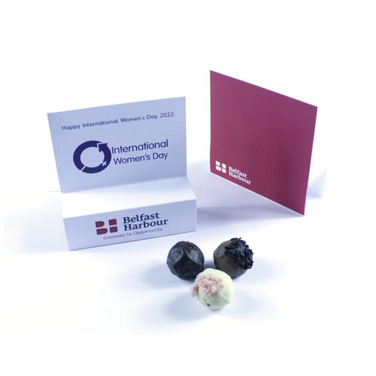 Three decorative chocolates in front of greeting cards from Belfast Harbour, celebrating International Women's Day 2022.