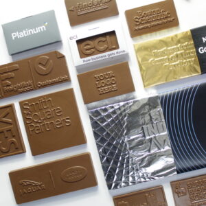 Assorted chocolate bars and wafers with embossed logos and designs displayed on a white surface.