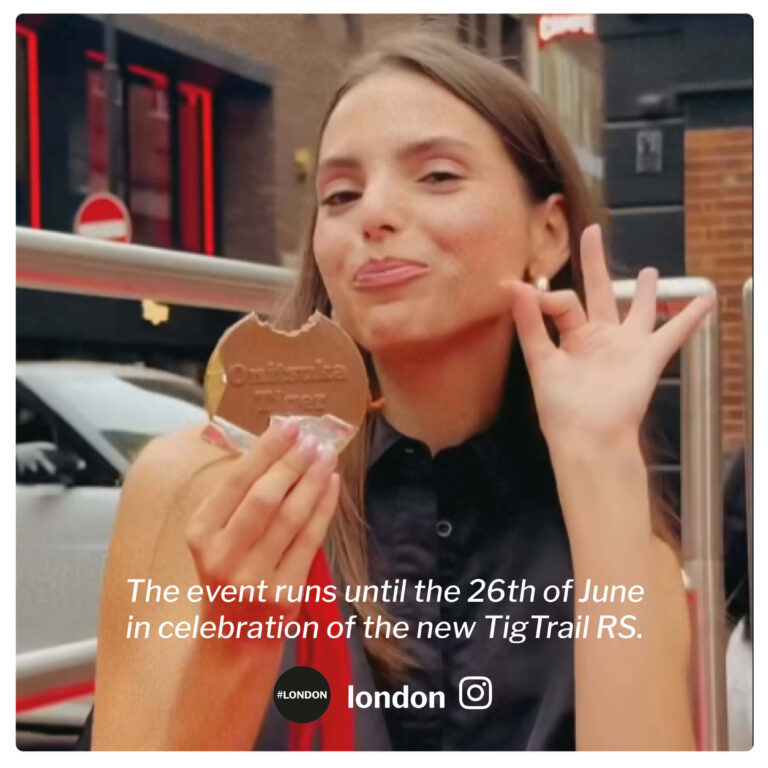 Woman eating a luxury Belgian chocolate bespoke design chocolate medal at a promotional event. Benefits of edible branded merchandise