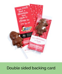 A chocolate Santa lollipop accompanied by a red double-sided card showcasing Christmas-themed text and designs.