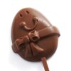 Eggbert Lollipop: a chocolate lollipop shaped like an egg with a smiling face and bow decoration.