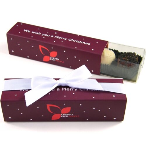 four-truffle-finger-box-with-bow-christmas Two Christmas 4 Chocolate Personalised Finger Boxes showing a purple design with white polka dots and "Cherry Pick People" logo, each adorned with a white ribbon. One box is open, revealing a clear compartment holding a truffle.