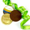 img_4080_-_m2_0724.2 The "Medals with Branded Ribbon" features a chocolate medallion inscribed with "You're a winner," accompanied by a gold-wrapped medallion and complemented by a green ribbon with white text.