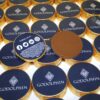 A display of Branded Chocolate Coins wrapped in gold foil with "GODOLPHIN" branding is visible. One coin is unwrapped, and the wrapper showcases social media icons.