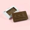A Bespoke Chocolate Bar - Branded Window Box with "eci" embossed rests next to its open white box on a pink background.