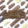 motorcycle_2 The "Chocolate Motorcycle" features a large motorcycle-shaped chocolate centerpiece, surrounded by smaller vehicle-shaped chocolates, all presented on a white background.