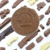 A large circular chocolate embossed with "Skoda Auto" is surrounded by various vehicle-shaped chocolates in the Skoda Chocolate Gifts set.