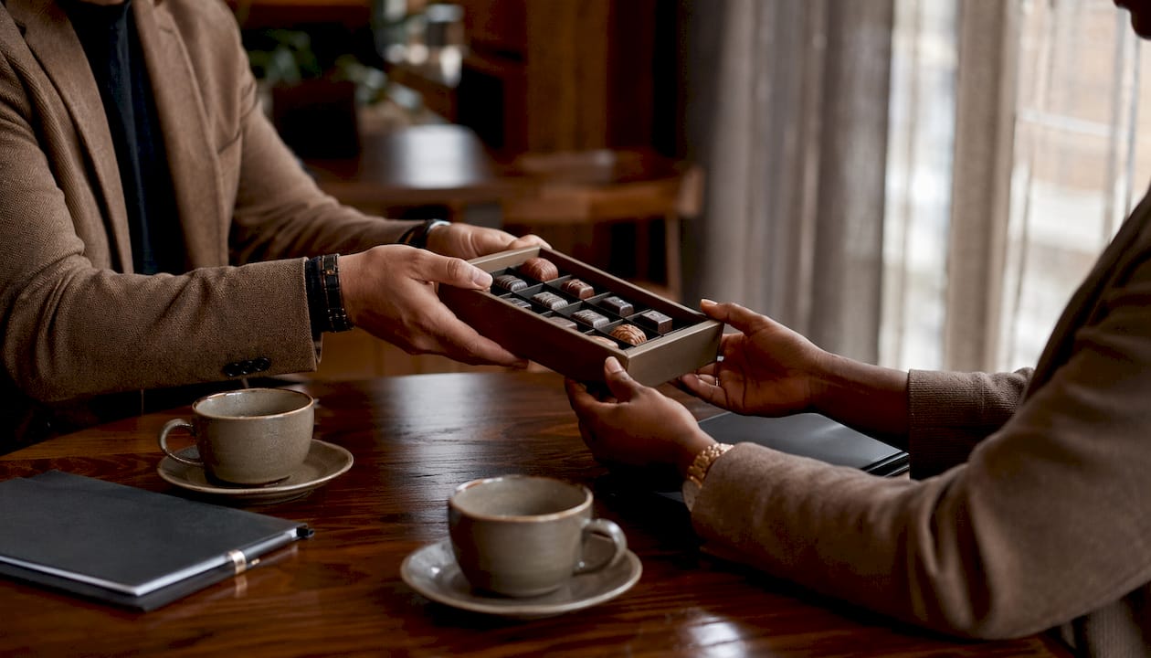 Hands exchanging premium chocolate gift