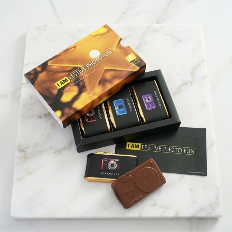 see the benefits of luxury client gifting in this premium branded black box with a gold branded lid with bespoke handmade chocolate cameras inside.